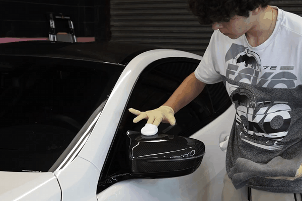 Technician applying ceramic coating to an applicator pad at Quality Auto Spa in St. James, NY.